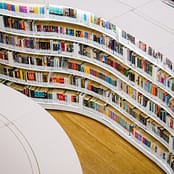 Kirjoja kaarevassa kirjahyllyssä kirjastossa