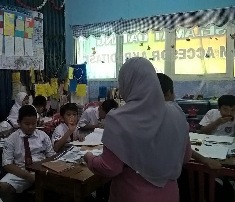 Opettaja ja oppilaita Indonesialaisessa luokkahuoneessa